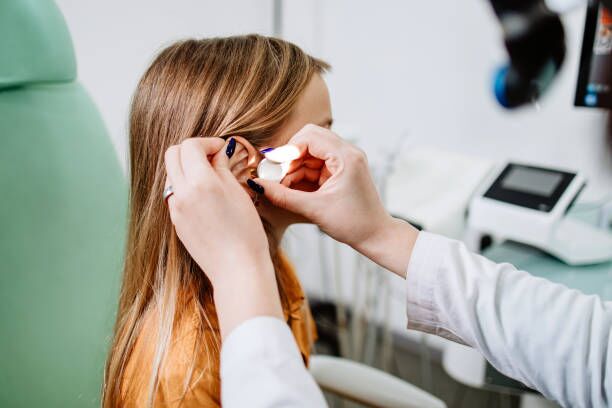 Medical hearing examination Female audiologist examining girl ear using otoscope in doctors office. Child receiving a ear exam. Nose and throat medical examination. Healthcare and medicine concept. child hearing aid stock pictures, royalty-free photos & images